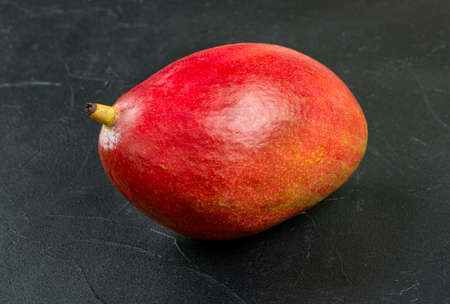 Red ripe mango fruit on a dark backgroundの写真素材