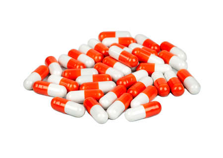 Pile of red and white capsules on a light backgroundの写真素材
