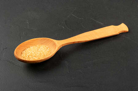 Large wooden spoon with brown sugar on a concrete backgroundの写真素材