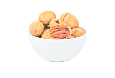 Shelled pecans in a ceramic light bowl on a white backgroundの写真素材