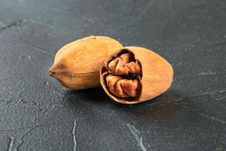 Inshell pecan with split half on dark concrete backgroundの写真素材