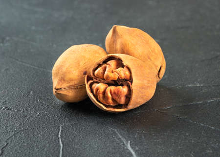 Three shelled pecans nuts close-up on a dark concrete backgroundの写真素材