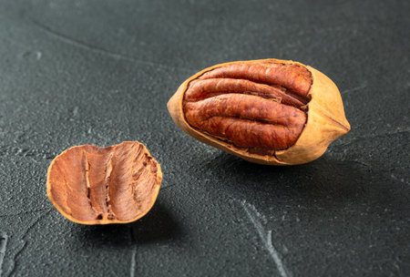 Cracked in-shell pecan close-up on dark concrete backgroundの写真素材