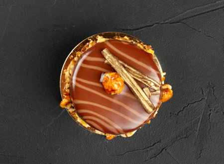 Beautiful chocolate brownie with nuts and salted caramel on a dark concrete background, top view.の写真素材