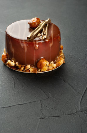 Beautiful chocolate brownie with mascarpone and salted caramel on a dark concrete background.の写真素材
