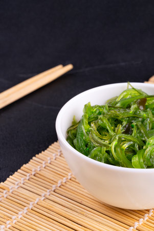 White plate with chuka seaweed close-up on a dark backgroundの写真素材
