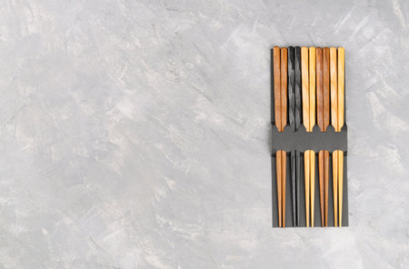 Multi-colored chopsticks in packaging on a concrete background, top view. Copy spaceの写真素材