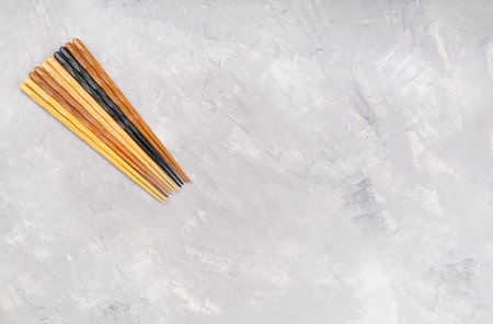 Several colorful Chinese chopsticks on an empty concrete background, top view. Copy spaceの写真素材