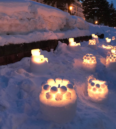 Beautiful lighted candles in the snow at night in the city