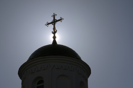 Dome of the church with a cross on a background of the sun.の写真素材