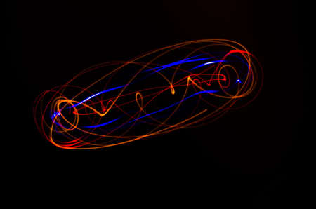Light spiral, red and blue lines on a black backgroundの写真素材