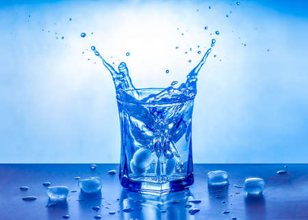 Ice splashing in a cool glass of water.の写真素材