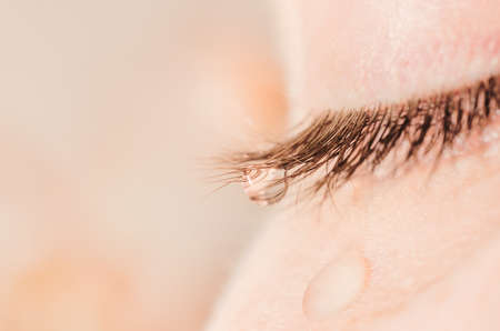 A tear on eyelashes and cheek.