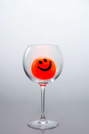 Orange ball with a smile in the glass.の写真素材