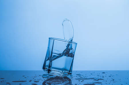 Splash in a glass of water on a blue background.