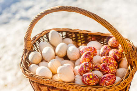 Colorful wooden Easter eggs hand-painted in a basket.の写真素材