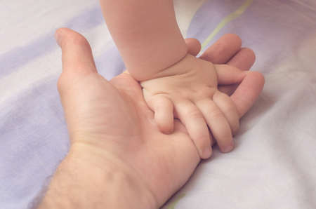 Little baby hand in father's hand.の写真素材