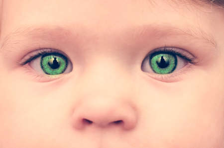 Baby face with green eyes, close-up.の写真素材