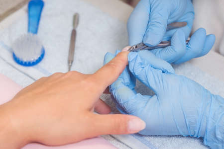 The master prepares the nails for manicure.