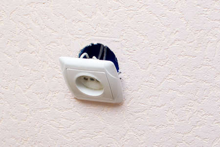 Old broken electrical socket fell out of wall.の写真素材