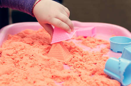 The hands of a child playing with kinetic sand.の写真素材