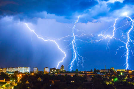 Thunderstorm with lightning above the night city.の写真素材
