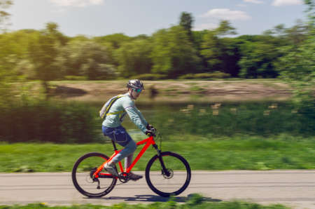 A cyclist in a helmet rides a bicycle path, motion blur.の写真素材