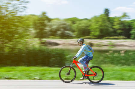 A cyclist in a helmet rides a bicycle path, motion blur.の写真素材