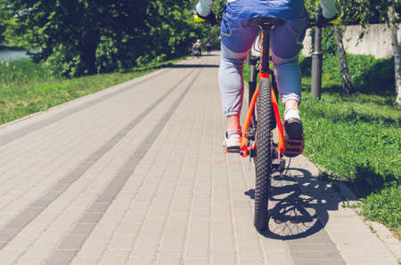 Cyclist on an orange bike riding a bicycle path.の写真素材