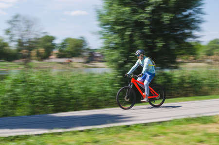 A cyclist in a helmet rides a bicycle path, motion blur.の写真素材