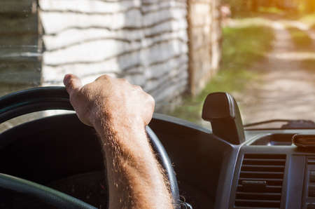 The driver's hands on the steering wheel of the car.の写真素材