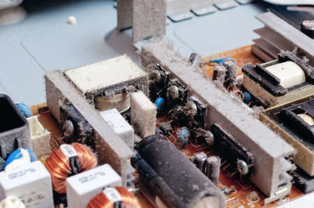 A thick layer of dust covers the internal electronic components of the computer.