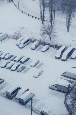 Cars covered with snow in the parking lot during a snowfall.の写真素材