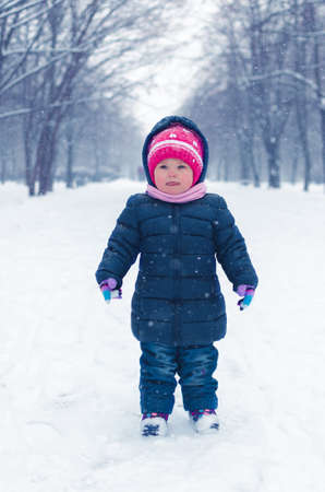 Little girl walks on the street in the winter day.の写真素材
