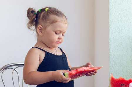 Portrait of a little girl eating a slice of juicy ripe watermelon.の写真素材
