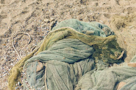 Fishing nets folded on the seashore, background texture.の写真素材