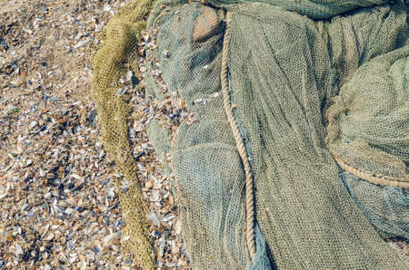 Fishing nets folded on the seashore, background texture.の写真素材