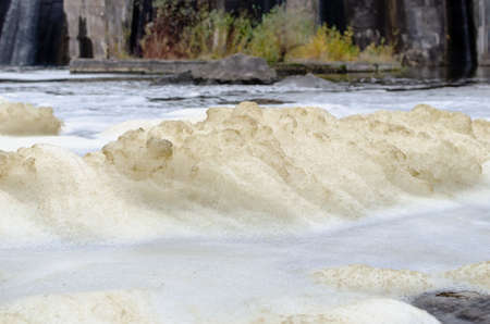 Foam on the surface of the water as a result of the discharge of water from the dam.の写真素材