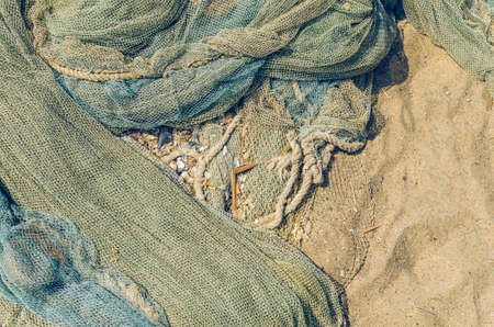 Fishing nets folded on the seashore, background texture.の写真素材
