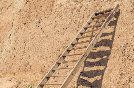 Wooden staircase attached to a clay rock on a sunny day.の写真素材