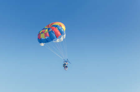 Parasailing is an extreme sport, people fly by parachute against the blue sky.の写真素材