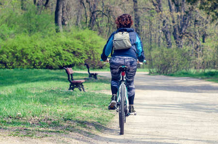 Girl riding a bike in a city park.