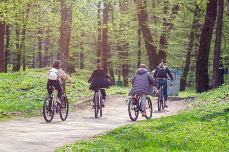 A group of cyclists ride in the city park.