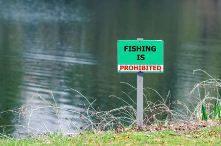 A sign prohibiting fishing in the pond.