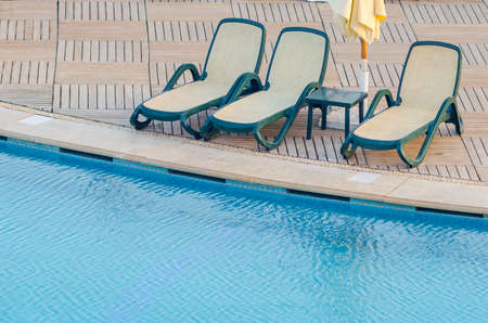 Swimming pool near the hotel with sun lounger and umbrella.の写真素材