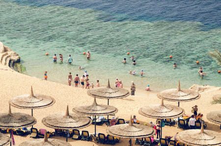 Sharm El Sheikh, Egypt, May 07, 2019: people sunbathe on sun loungers under umbrellas on the beach and bathe in the sea in Egypt.のeditorial素材