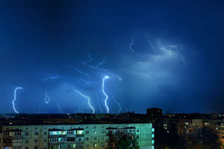 Thunderstorm with lightning and thunder over the night city.の写真素材