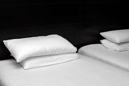 White sheets and pillow at the head of the black bed.