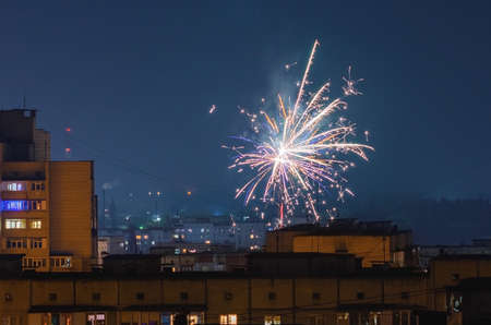 Beautiful fireworks over the roofs of houses.の写真素材