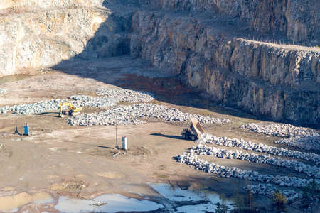 Excavator and heavy mining truck in a granite quarry.の写真素材